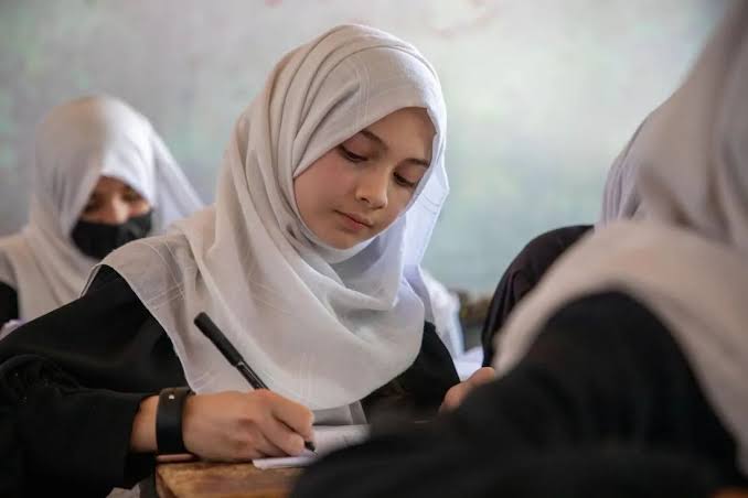 Afghan female student writing in class